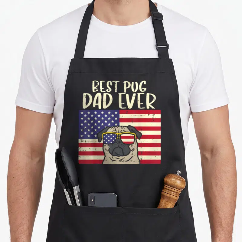 Tablier de cuisine noir avec illustration d'un carlin portant des lunettes de soleil devant un drapeau américain.