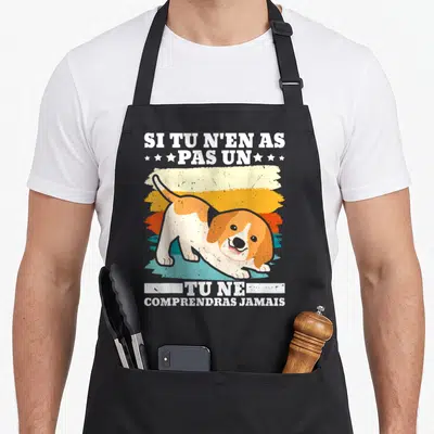 Tablier de cuisine noir avec un beagle orange et blanc étiré sous des bandes de couleur vintage et du texte humoristique en blanc.