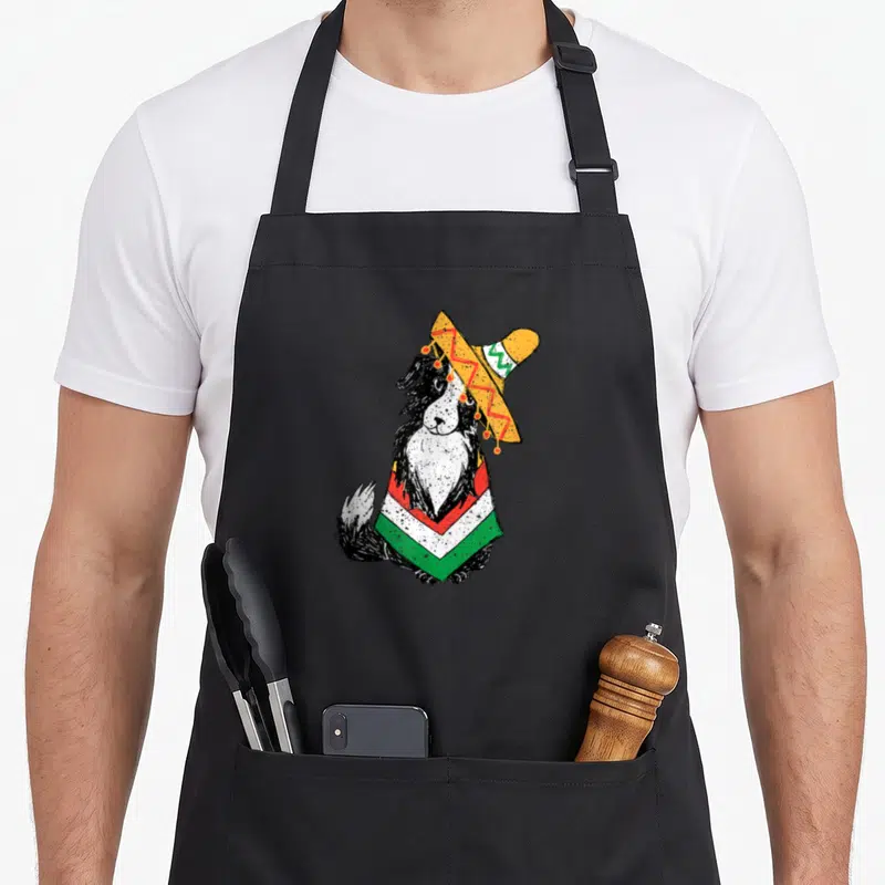 Tablier de cuisine noir avec illustration d'un chien portant un sombrero et un poncho aux couleurs du Mexique.
