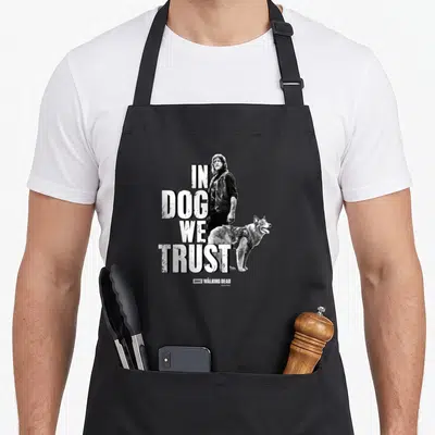 Tablier de cuisine noir avec illustration de Daryl Dixon et un chien sous le texte In Dog We Trust.