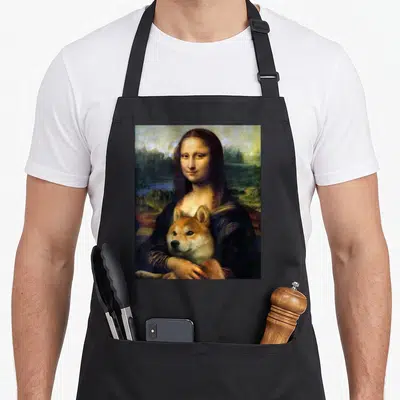Tablier de cuisine noir avec une reproduction de la Mona Lisa tenant un chien Shiba Inu dans ses bras.