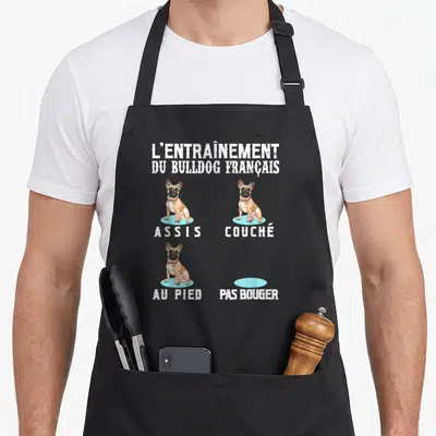 Tablier de cuisine noir avec illustration d'un bulldog français et les mots assis couché au pied pas bouger.