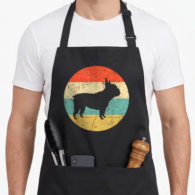 Tablier de cuisine noir avec une silhouette de bouledogue français sur un cercle aux bandes colorées style vintage.