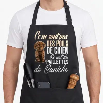 Tablier de cuisine noir avec illustration d'un chiot caniche brun et texte humoristique sur fond uni.