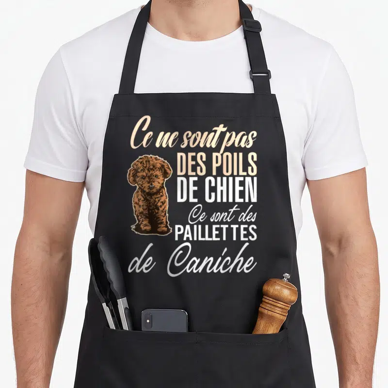 Tablier de cuisine noir avec illustration d'un chiot caniche brun et texte humoristique sur fond uni.