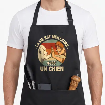 Tablier de cuisine noir avec illustration vintage d'un homme et d'un chien se donnant la patte sous le texte « La vie est meilleure avec un chien ».