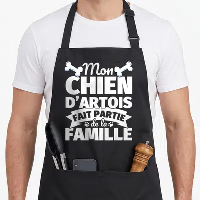 Tablier de cuisine noir avec inscription Mon chien d'Artois fait partie de la famille orné d'os et de traces de pattes blanches.