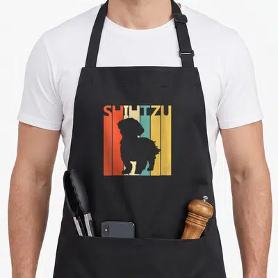 Tablier de cuisine noir avec silhouette grise Shih Tzu sur fond de bandes colorées orange jaune et turquoise.