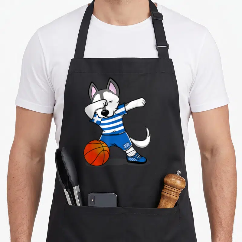 Tablier de cuisine noir avec illustration d'un husky en train de faire le dab près d'un ballon de basket orange.
