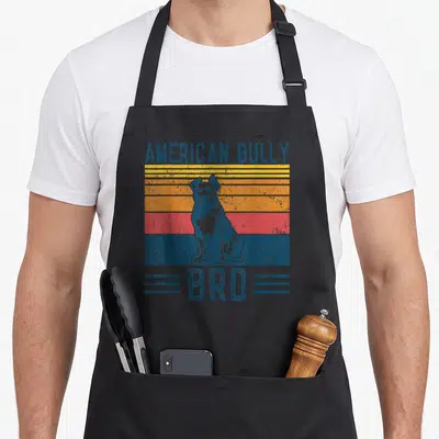 Tablier de cuisine noir avec illustration vintage d'un American Bully Bro sur fond de bandes colorées.