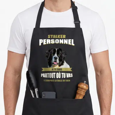 Tablier de cuisine noir avec portrait de chien Landseer et texte humoristique en blanc et doré.
