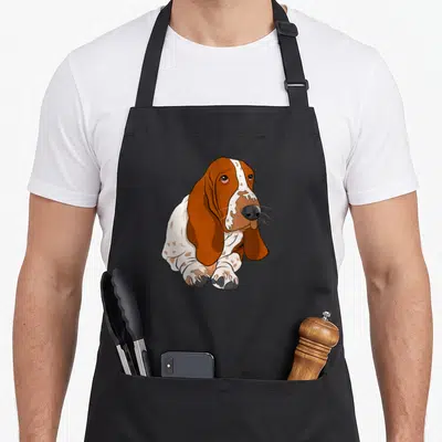 Tablier de cuisine noir avec illustration d'un chiot basset hound aux oreilles longues et au regard tendre.
