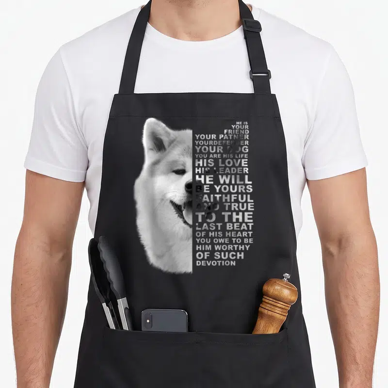Tablier de cuisine noir avec portrait d'Akita et texte sur la fidélité canine en typographie blanche.