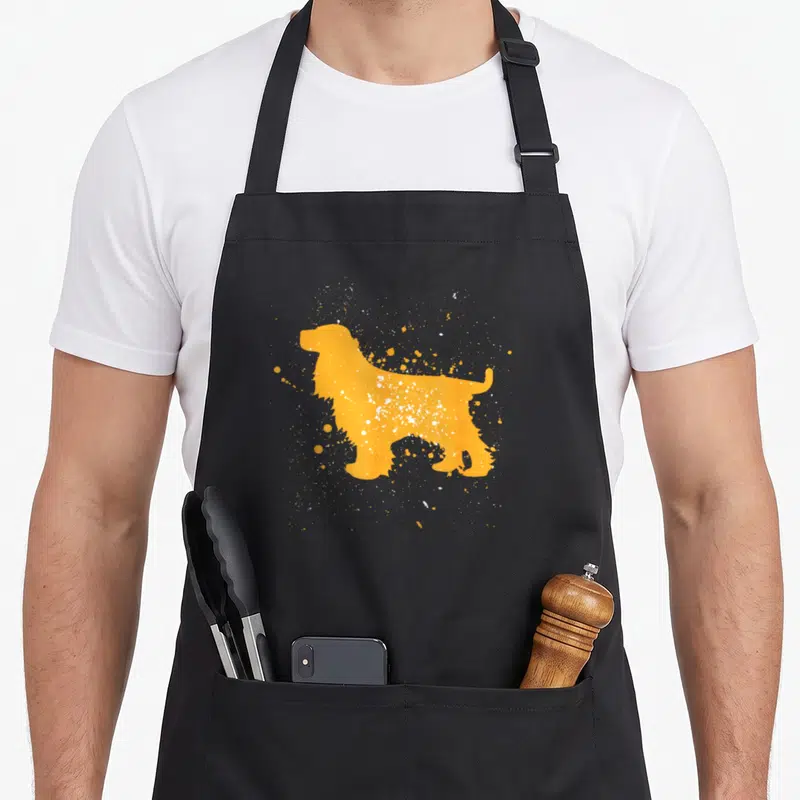 Tablier de cuisine noir avec silhouette orange d'English Cocker Spaniel et éclaboussures blanches.