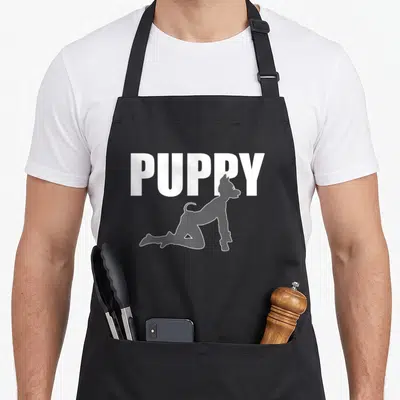 Tablier de cuisine noir avec l'inscription PUPPY et une silhouette de chien en position de jeu.