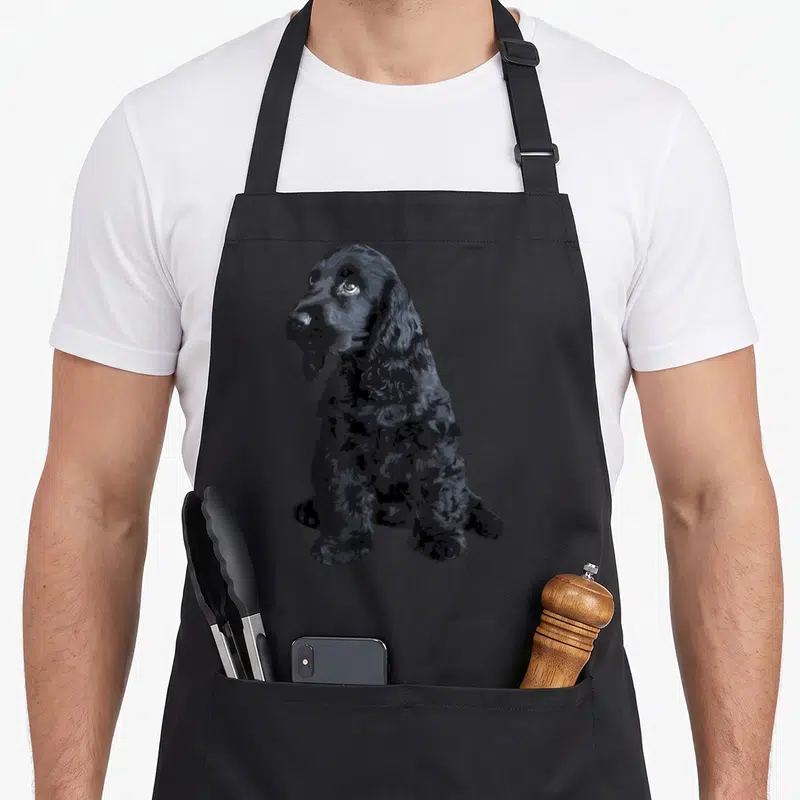 Tablier de cuisine noir avec illustration d'un chiot de Cocker Anglais noir assis de profil