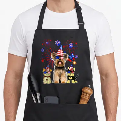 Tablier de cuisine noir avec trois chiens Yorkshire Terrier en fête, chapeaux et lunettes aux couleurs du drapeau américain.