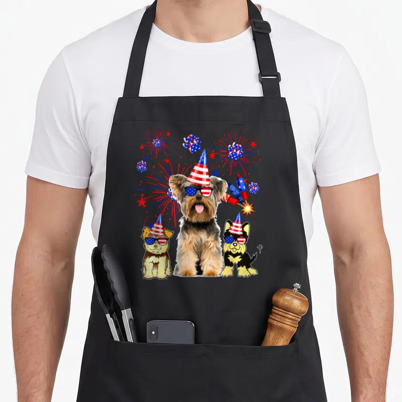 Tablier de cuisine noir avec trois chiens Yorkshire Terrier en fête, chapeaux et lunettes aux couleurs du drapeau américain.