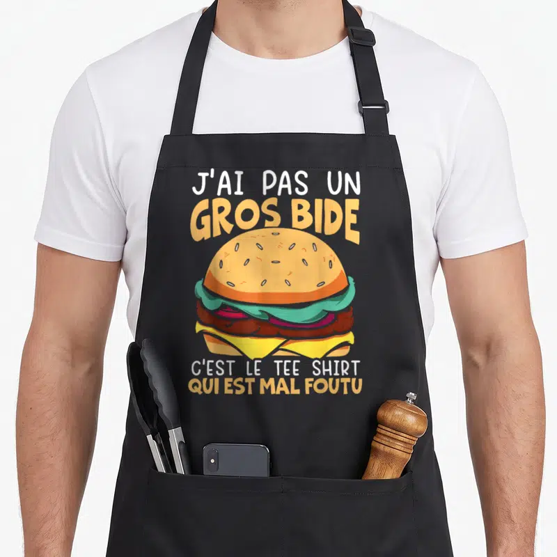 Tablier de cuisine noir avec illustration d'hamburger coloré et texte humoristique en blanc et orange.