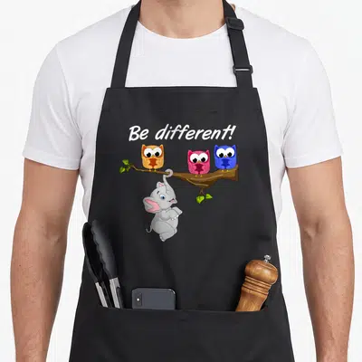 Tablier de cuisine noir avec inscription Be Different et dessin d'un éléphant suspendu sous trois hiboux sur une branche.