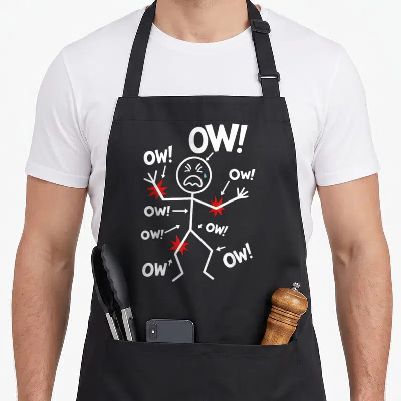 Tablier de cuisine noir avec un personnage en stick figure entouré de texte Ow. et d'étoiles rouges marquant les points de douleur.