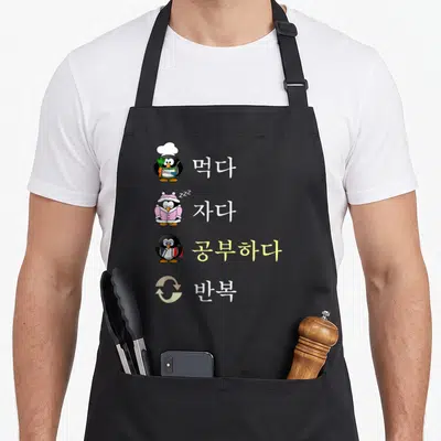 Tablier de cuisine noir avec quatre pingouins illustrant les étapes d'un cycle de vie d'étudiant intensif.