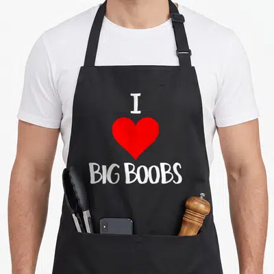 Tablier de cuisine noir avec inscription blanche I Love Big Boobs surmontant un cœur rouge vif au centre du torse.