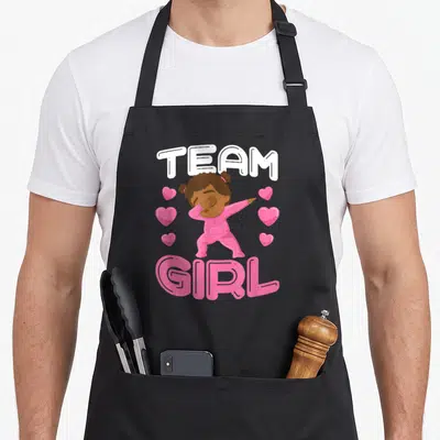 Tablier de cuisine noir avec une illustration rose d'une enfant faisant un dab sous les mots Team Girl.