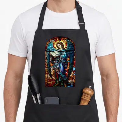 Tablier de cuisine noir avec une illustration en vitrail de Saint Gabriel Archange tenant un livre ouvert aux ailes déployées.