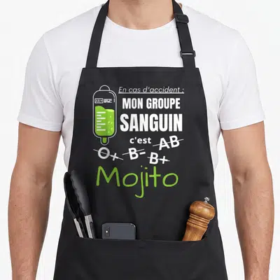 Tablier de cuisine noir avec illustration poches à droites et texte blanc vert sur fond gris uni