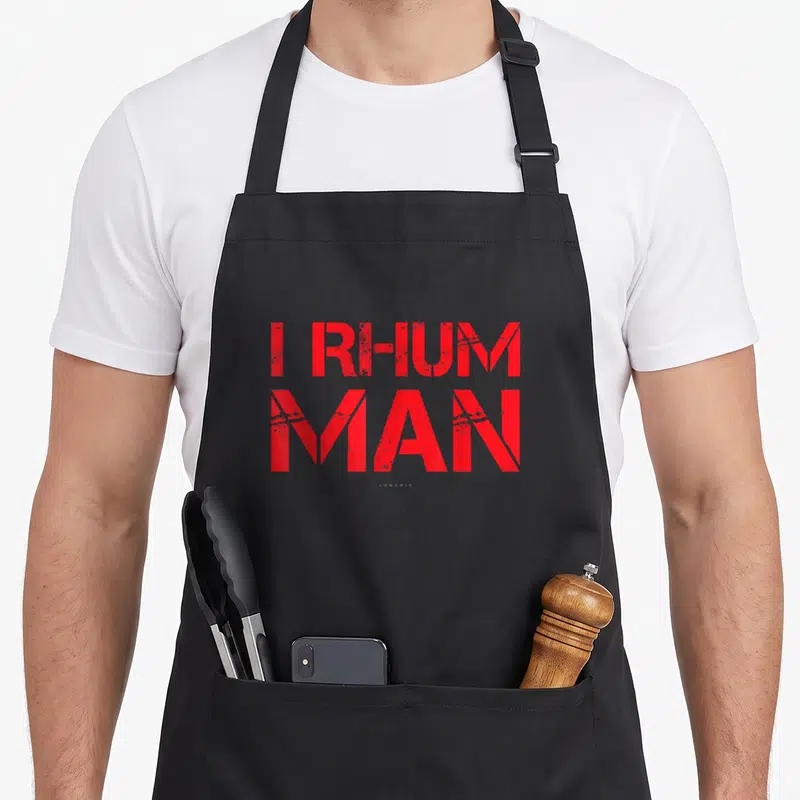 Tablier de cuisine noir avec l'inscription I Rhum Man en lettres rouges stylisées sur le devant.