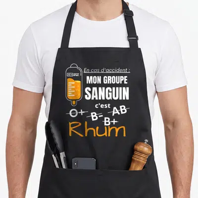 Tablier de cuisine noir avec illustration poche à perfusion orange et texte sur le rhum comme groupe sanguin.