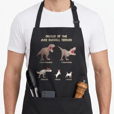 Tablier de cuisine noir avec une illustration montrant l'évolution d'un dinosaure vers un terrier en cinq étapes.