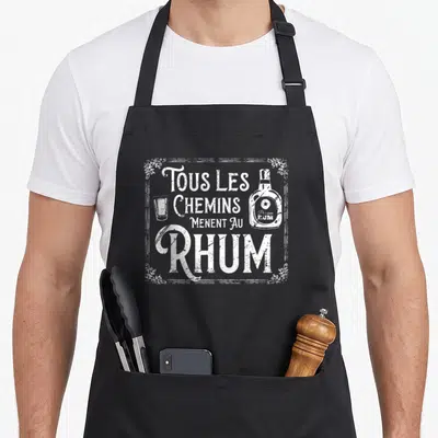 Tablier de cuisine noir avec inscription tous les chemins menent au rhum et illustration vintage d'une bouteille de rhum.
