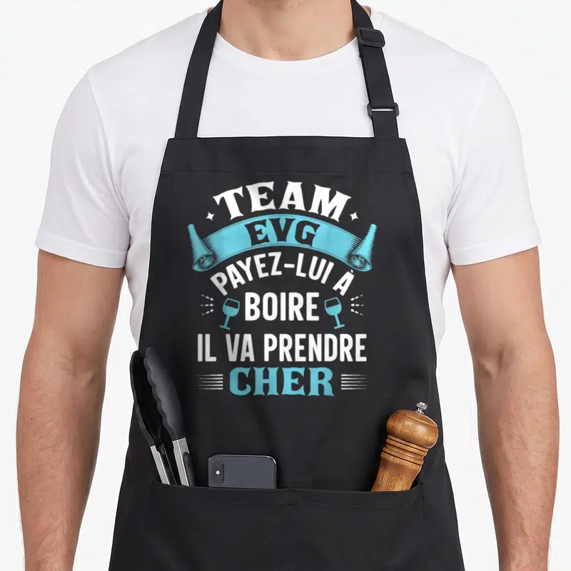 Tablier de cuisine noir avec le texte Team EVG payez-lui à boire il va prendre cher en blanc et bleu.