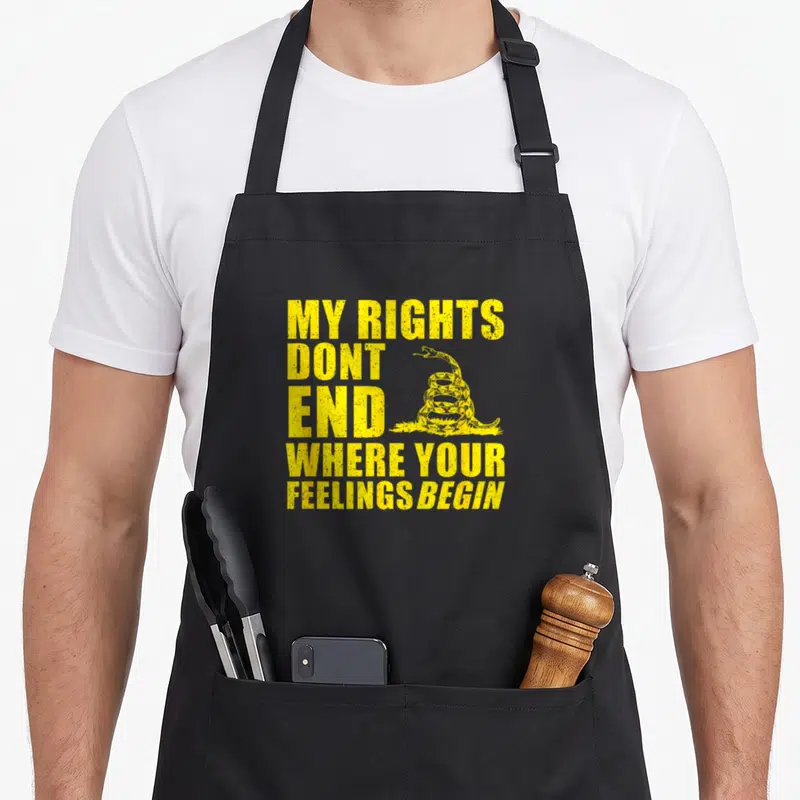 Tablier de cuisine noir avec inscription jaune My Rights Dont End Where Your Feelings Begin et serpent Gadsden stylisé.