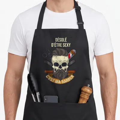 Tablier de cuisine noir avec un crâne à barbe, ciseaux et texte Désolé d'être sexy C'est ma barber