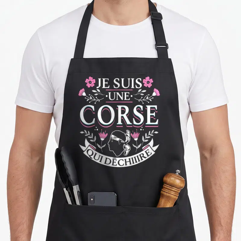 Tablier de cuisine noir avec inscription Je suis une Corse qui déchire et motifs floraux roses.