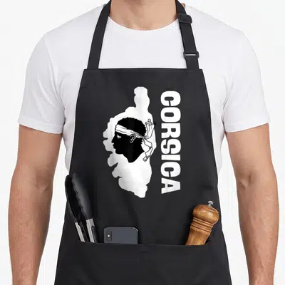 Tablier de cuisine noir avec une tête de maure blanche et le texte vertical CORSICA