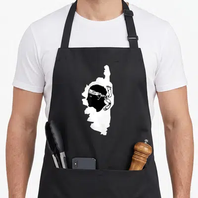 Tablier de cuisine noir avec silhouette blanche de l'île Corsica intégrant un profil de pirate au bandana.