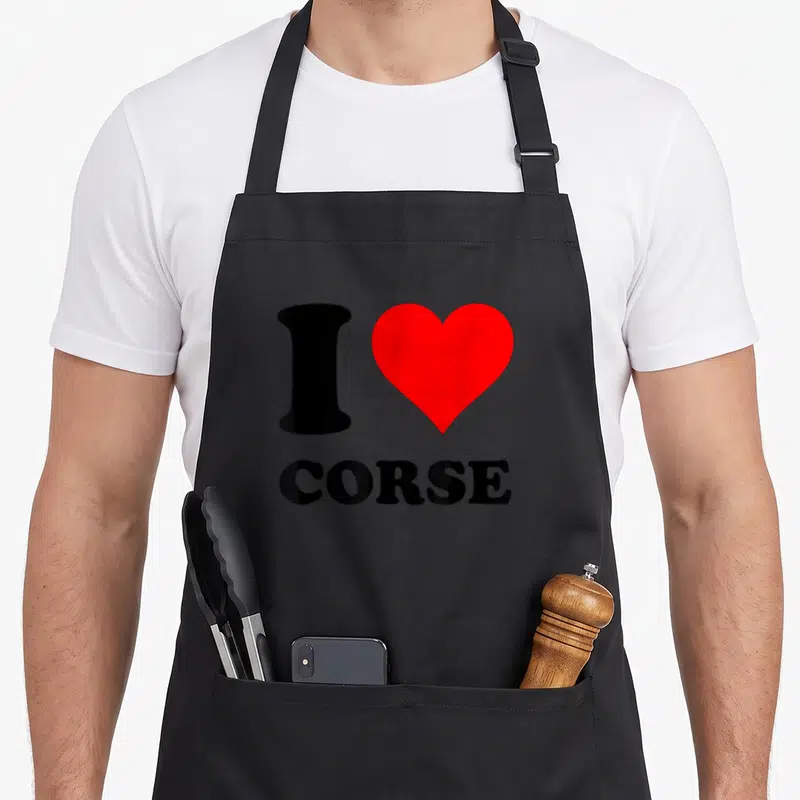 Tablier de cuisine noir avec le texte I Love Corse et un grand cœur rouge imprimé au centre du torse.