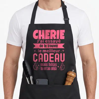 Tablier de cuisine noir avec inscription rose Chérie j'ai essayé de te trouver le meilleur cadeau mais hélas tu m'as déjà et deux pouces levés.