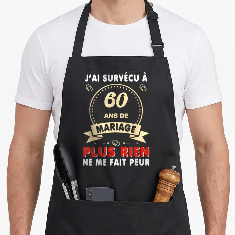 Tablier de cuisine noir avec inscription J'ai survécu à 60 ans de mariage et anneaux dorés sur fond gris uni.