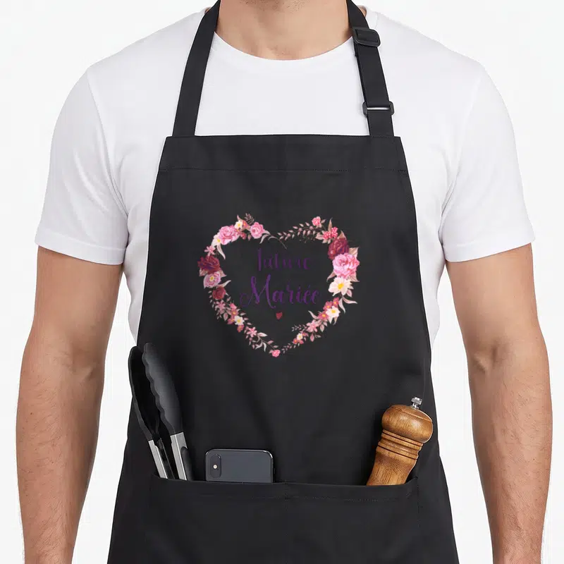 Tablier de cuisine noir avec un cœur floral rose et la mention Future Mariée en calligraphie violette.