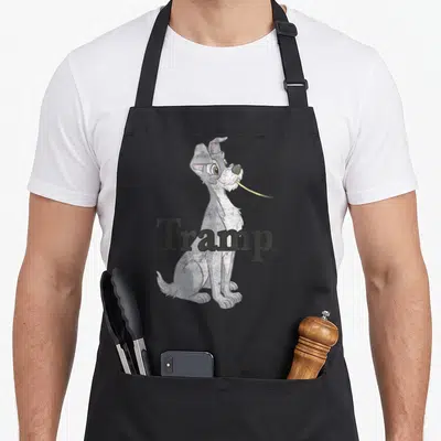 Tablier de cuisine noir avec illustration de Tramp chien gris assis et du mot Tramp imprimé en lettres foncées devant lui.