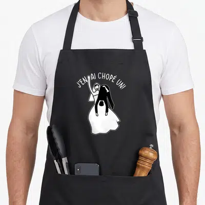 Tablier de cuisine noir avec une illustration d'un couple de mariés et le texte J'en ai chopé un.