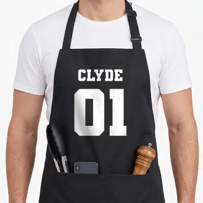 Tablier de cuisine noir avec l inscription blanche Clyde 01 en typographie sportive.