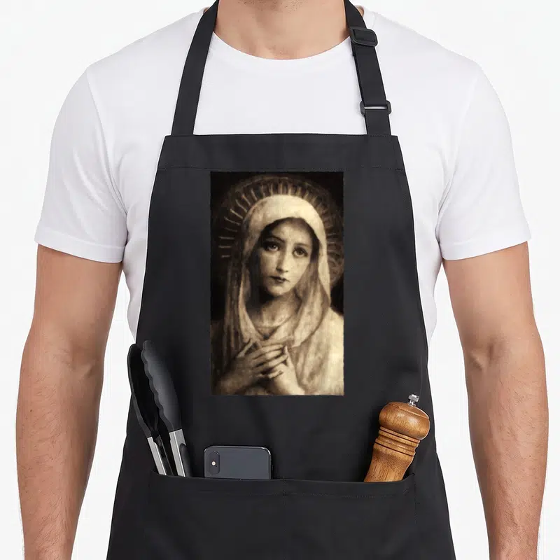 Tablier de cuisine noir avec une illustration de la Vierge Marie Maria aux mains jointes et halo rayonnant en tons sépia.