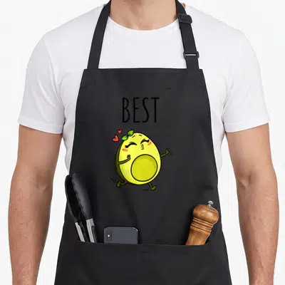 Tablier de cuisine noir avec illustration d'avocat jaune souriant, cœurs roses et texte best en lettres noires.