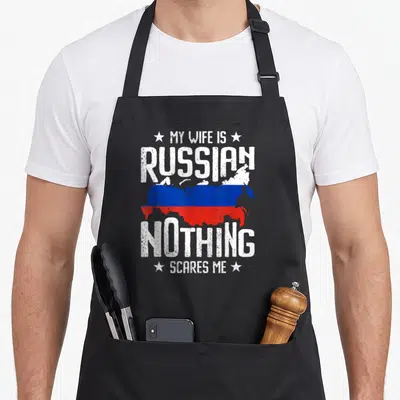 Tablier de cuisine noir avec l'inscription Ma femme est russe et une carte de Russie aux couleurs du drapeau.